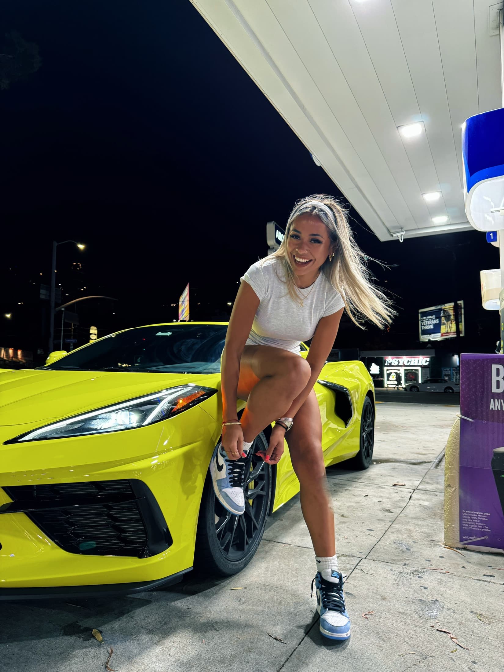 Ximena Saenz beside a sports car at night in Los Angeles